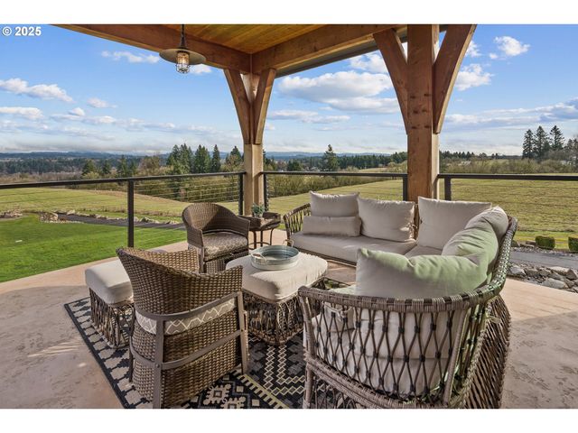 a view of a patio with couches potted plants and a big lake