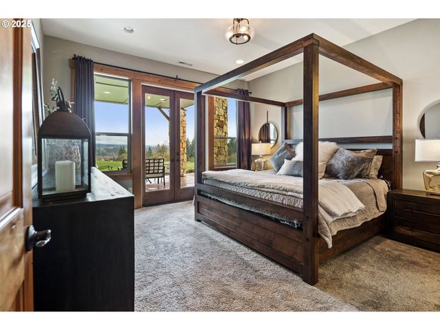 a bedroom with a bed lamp and large window