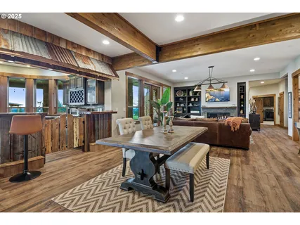 a dining hall view with a large dining table and chairs with wooden floor