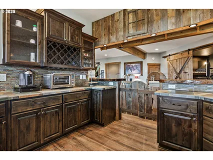 a kitchen with stainless steel appliances granite countertop a sink a stove and a wooden cabinets
