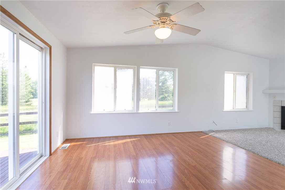 9690 Delta Line Road Blaine, WA 98230 - Photo 8 of 38 an empty room with wooden floor fan and windows