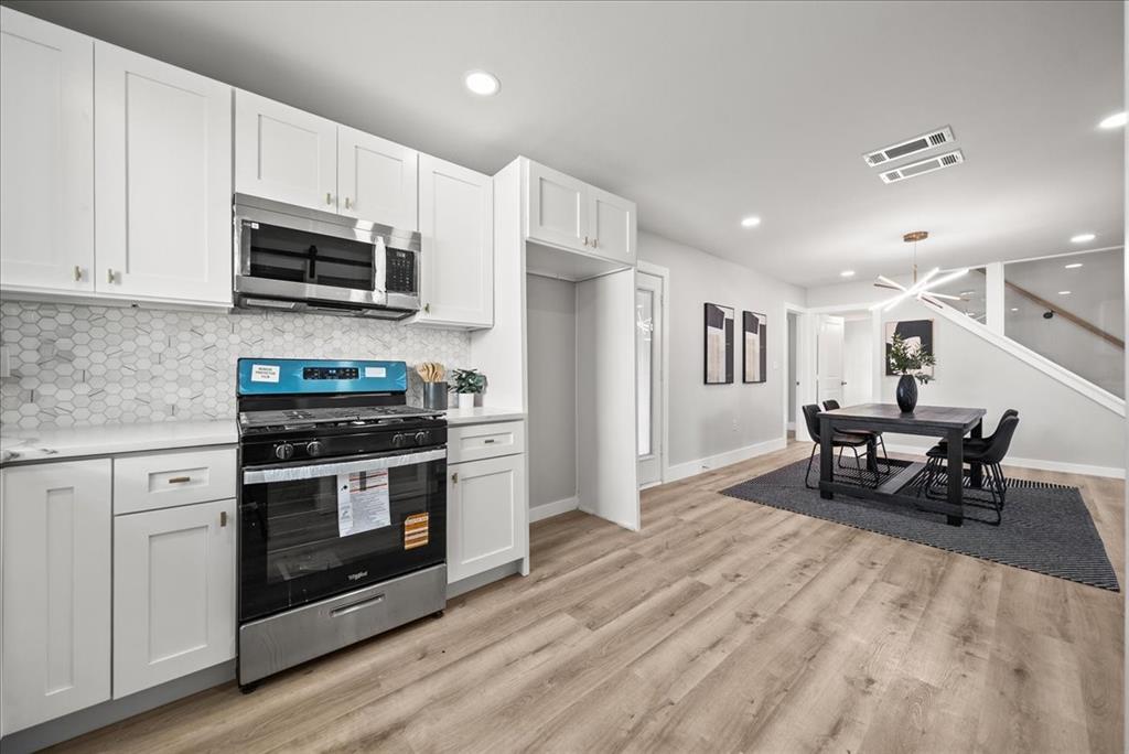 11630 Rupley Lane Dallas, TX 75218 - Photo 10 of 30 a kitchen with stainless steel appliances a stove a sink white cabinets and a refrigerator