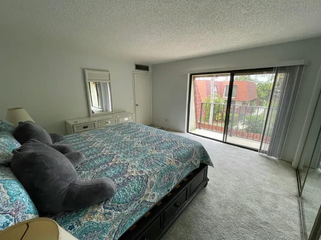 a spacious bedroom with a bed and glass door