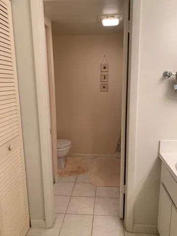 a bathroom with a granite countertop sink and a toilet