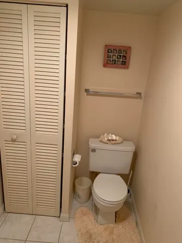 a white toilet sitting next to a white cabinet