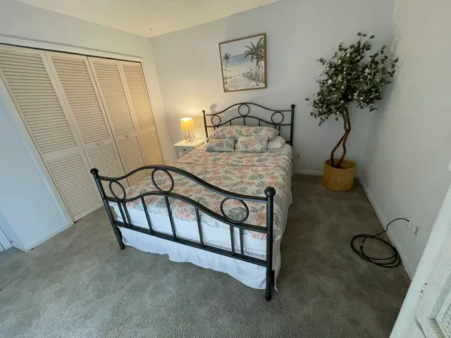a bedroom with a bed and a potted plant
