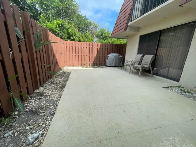 a backyard of a house with chairs and wooden fence