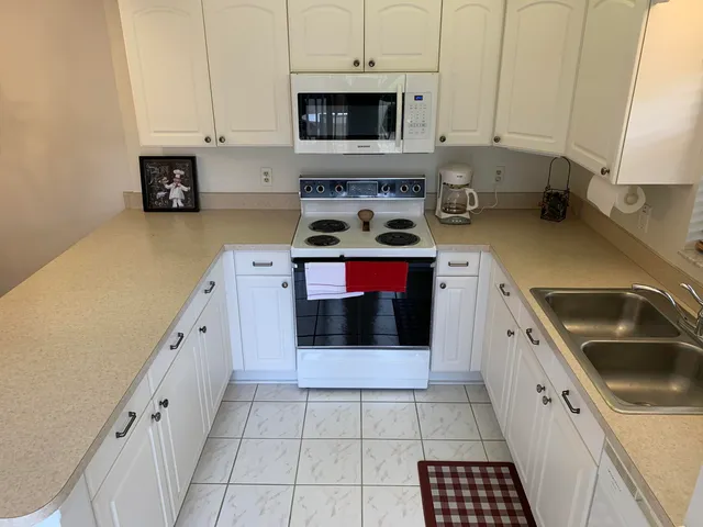 a kitchen with stainless steel appliances a stove a sink and a microwave