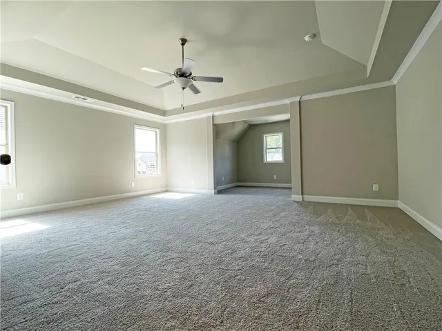 a view of a big room with windows and chandelier fan