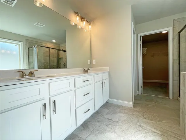 a spacious bathroom with 2 sink and a mirror