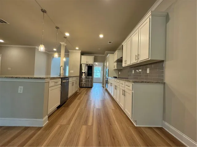 a view of a kitchen with a sink and wooden floor