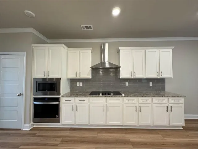 a kitchen with granite countertop a stove a sink and a microwave