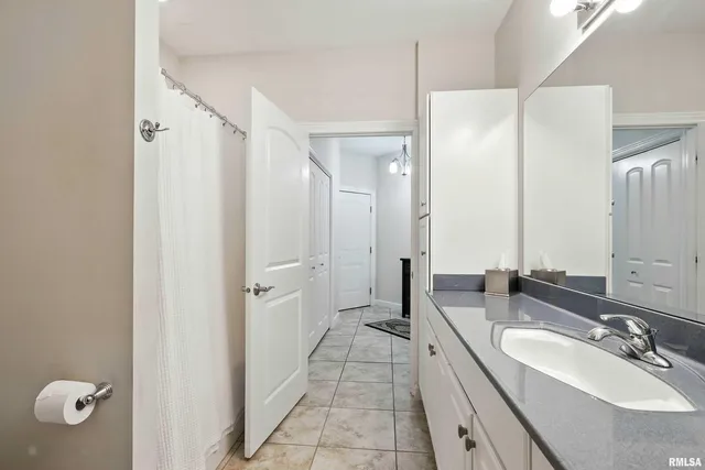 a spacious bathroom with a double vanity sink a mirror and a shower