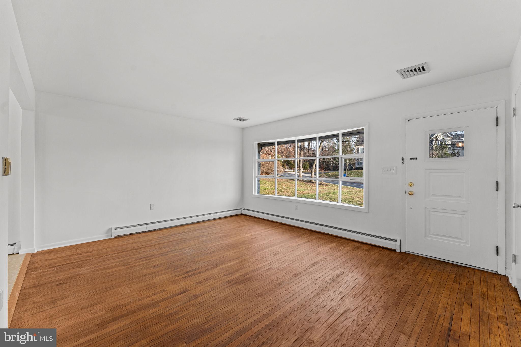 1687 Rupert Road Pottstown, PA 19464 - Photo 3 of 33 a view of an empty room with wooden floor and windows