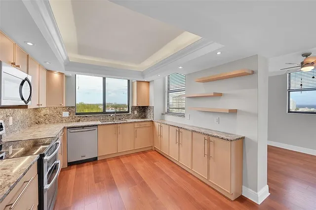 a kitchen with a sink wooden floor and stainless steel appliances