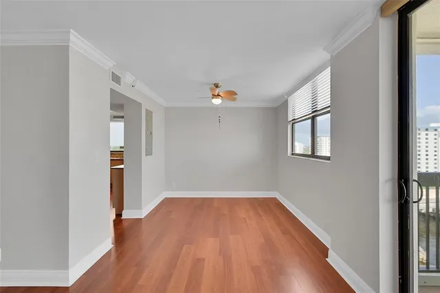 a view of empty room with wooden floor and fan