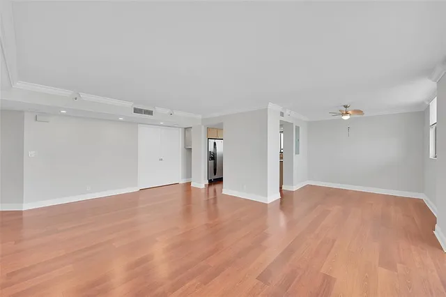 a view of an empty room with wooden floor