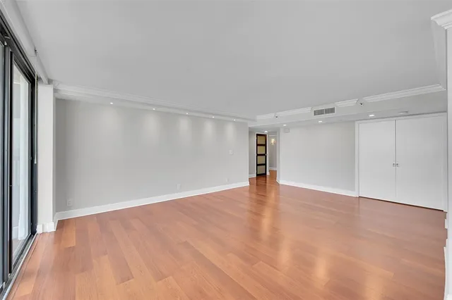 a kitchen with stainless steel appliances a refrigerator a sink dishwasher a stove and white cabinets with wooden floor