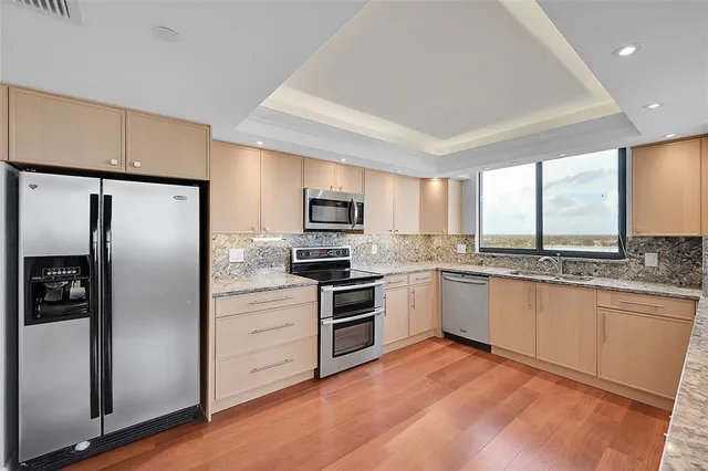 a kitchen with granite countertop a refrigerator and a sink