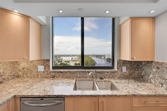a bathroom with a granite countertop sink and a large mirror