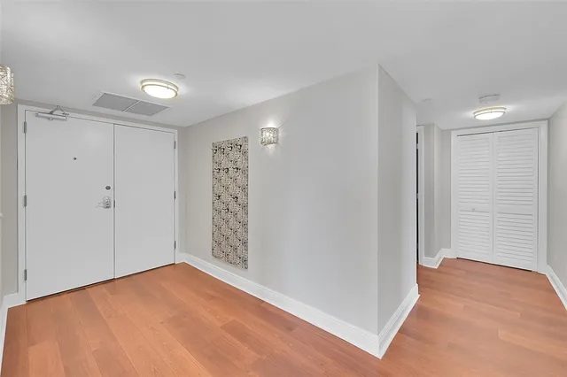 a view of a hallway with wooden floor and a living room