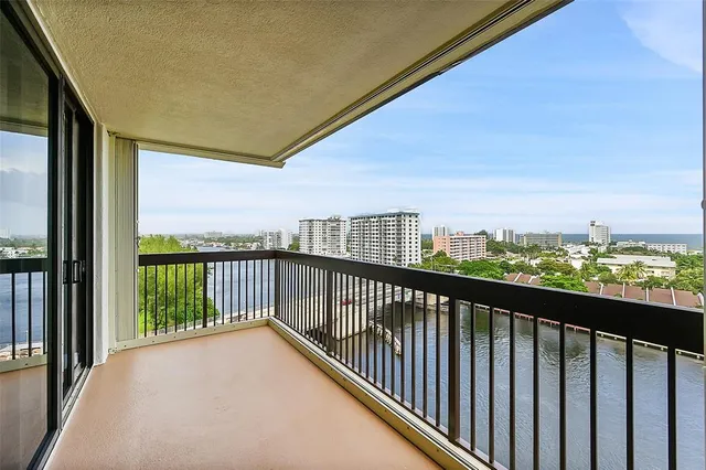 a view of a white house with a street and trees