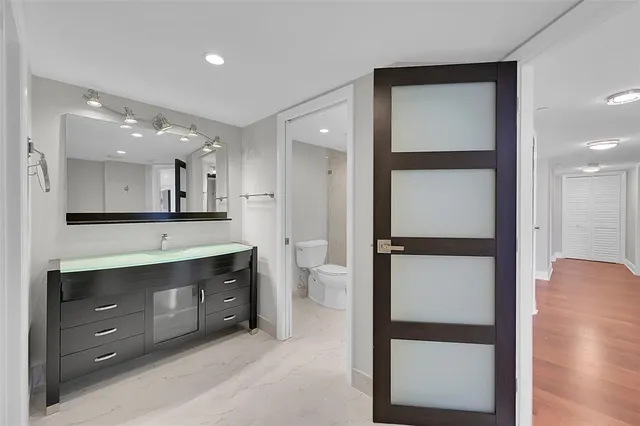 a spacious bathroom with a granite countertop sink mirror and toilet