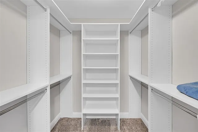 a view of walk in closet with empty racks