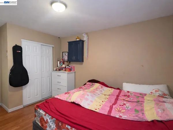 a bedroom with a bed and wooden floor