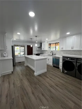 a large kitchen with stainless steel appliances granite countertop a stove oven and a sink with granite countertops