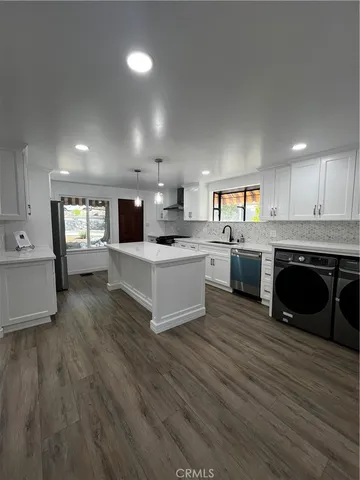 a large kitchen with stainless steel appliances granite countertop a stove and a sink
