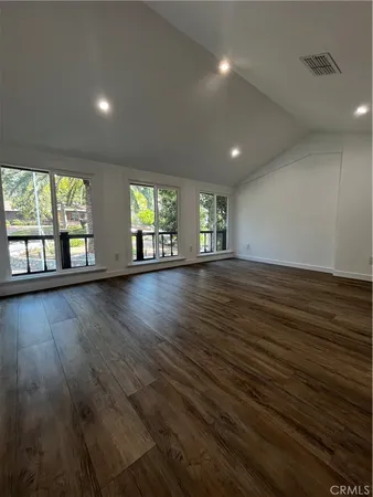 a view of a room with wooden floor and window