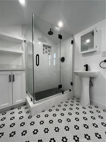 a bathroom with a sink a toilet a mirror and shower