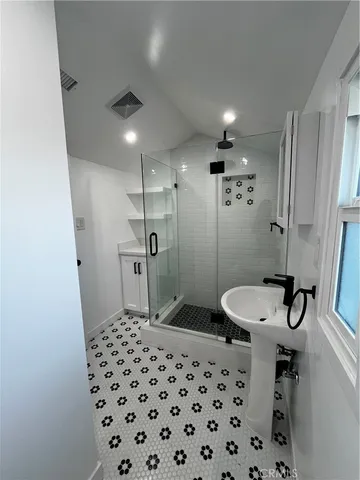 a bathroom with a sink a toilet a mirror and shower