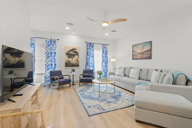 a view of dining room and livingroom with furniture wooden floor a chandelier