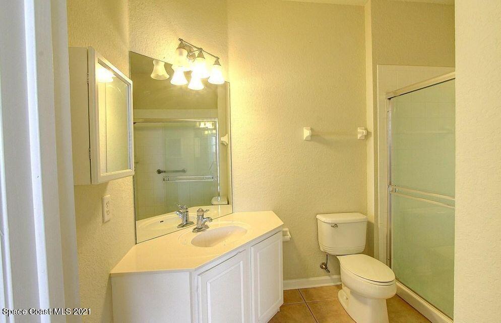 3848 Lexmark Lane, Unit 302 Rockledge, FL 32955 - Photo 12 of 18 a bathroom with a sink and mirror with toilet
