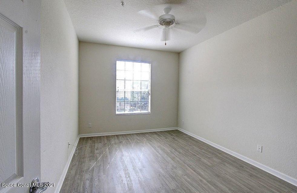 3848 Lexmark Lane, Unit 302 Rockledge, FL 32955 - Photo 13 of 18 an empty room with wooden floor and windows