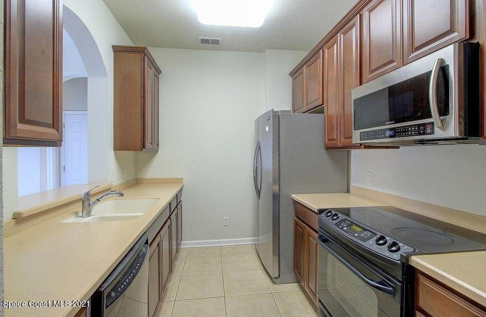 3848 Lexmark Lane, Unit 302 Rockledge, FL 32955 - Photo 7 of 18 a kitchen with stainless steel appliances granite countertop a sink stove and refrigerator