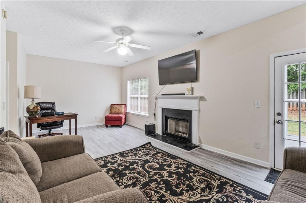 675 Michael Circle Monroe, GA 30655 - Photo 16 of 34 a living room with furniture a flat screen tv and a fireplace