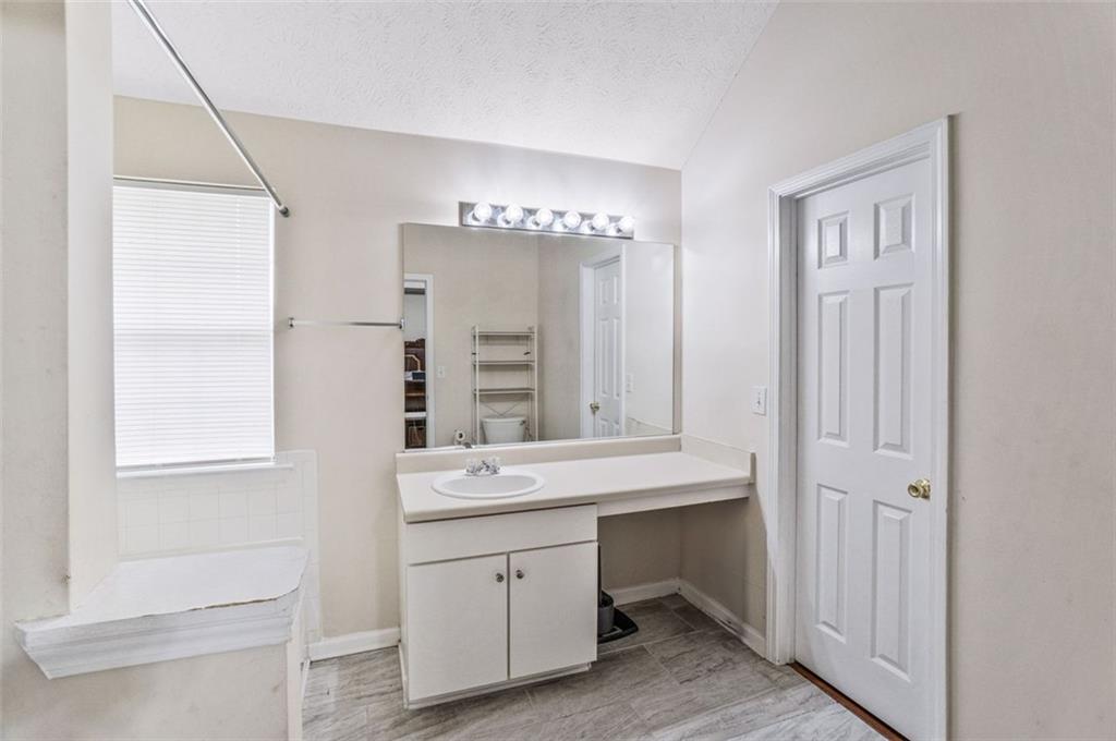 675 Michael Circle Monroe, GA 30655 - Photo 31 of 34 a bathroom with a double vanity sink a mirror and a bathtub