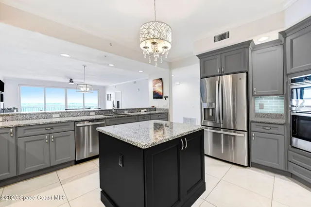 a kitchen with stainless steel appliances granite countertop a refrigerator and a stove top oven