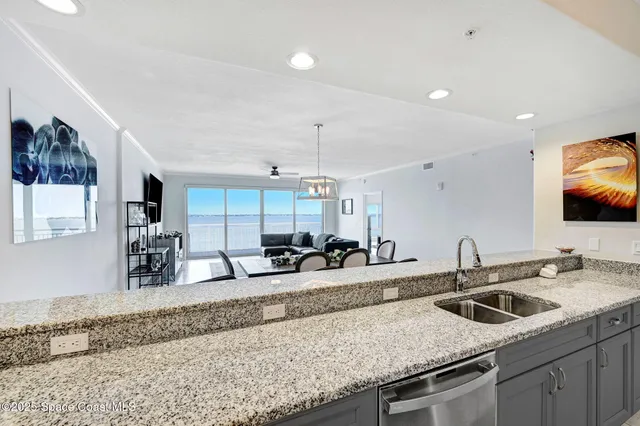 a kitchen with stainless steel appliances kitchen island granite countertop a table chairs in it and wooden floors