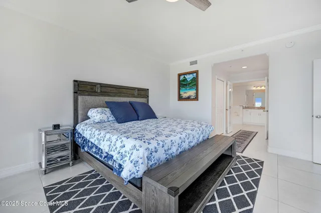 a bedroom with a bed and walk in closet with wooden floor