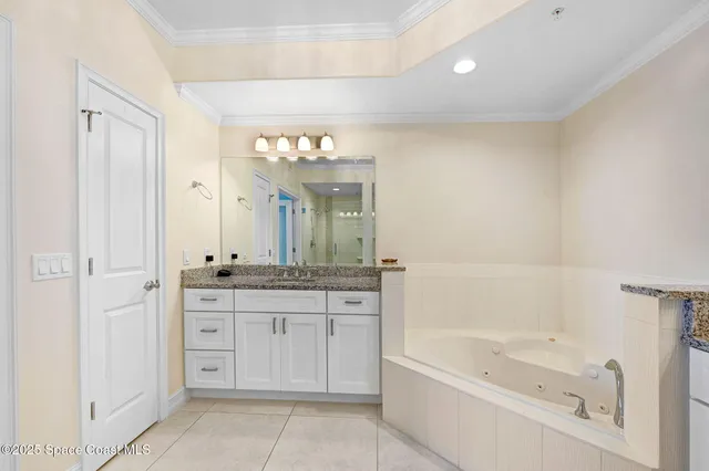 a spacious bathroom with a granite countertop sink a mirror a bathtub and shower