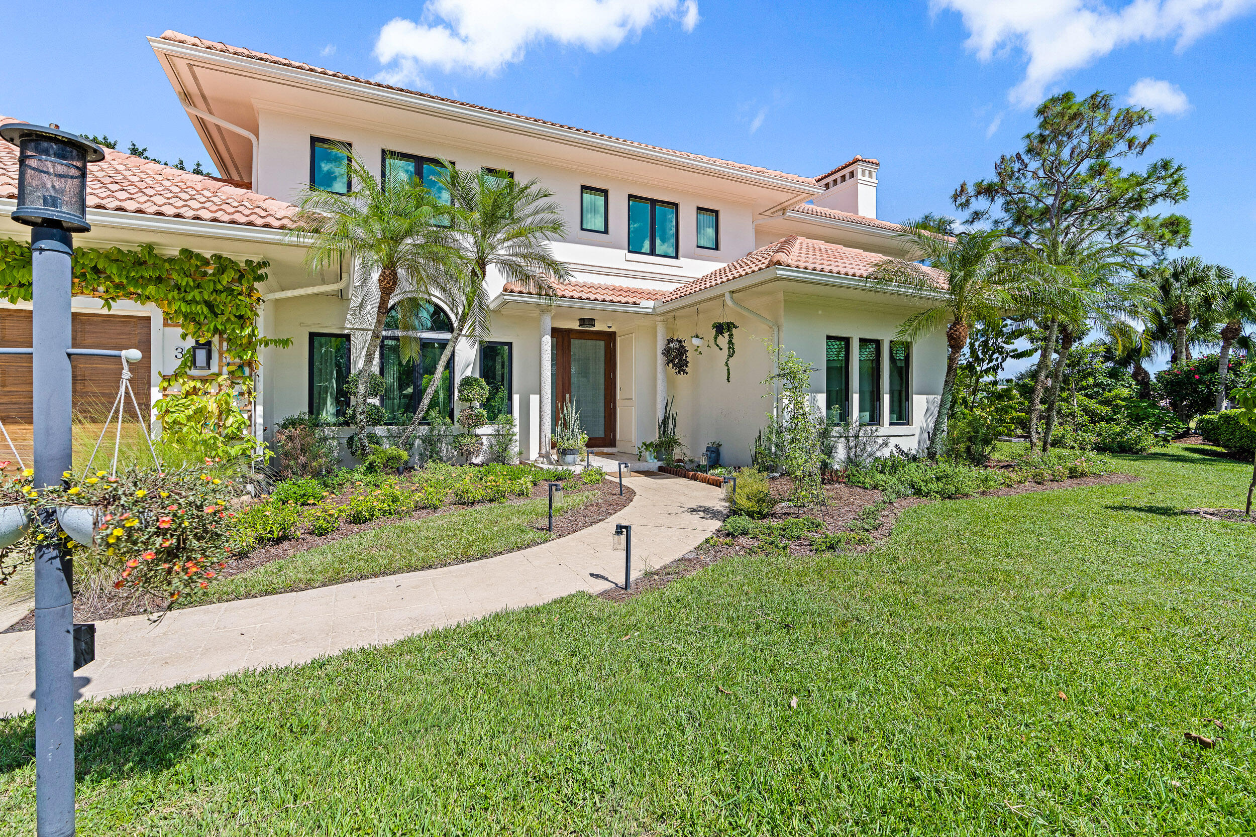3 Sheldrake Circle Palm Beach Gardens, FL 33418 - Photo 43 of 48 a front view of a house with porch and garden