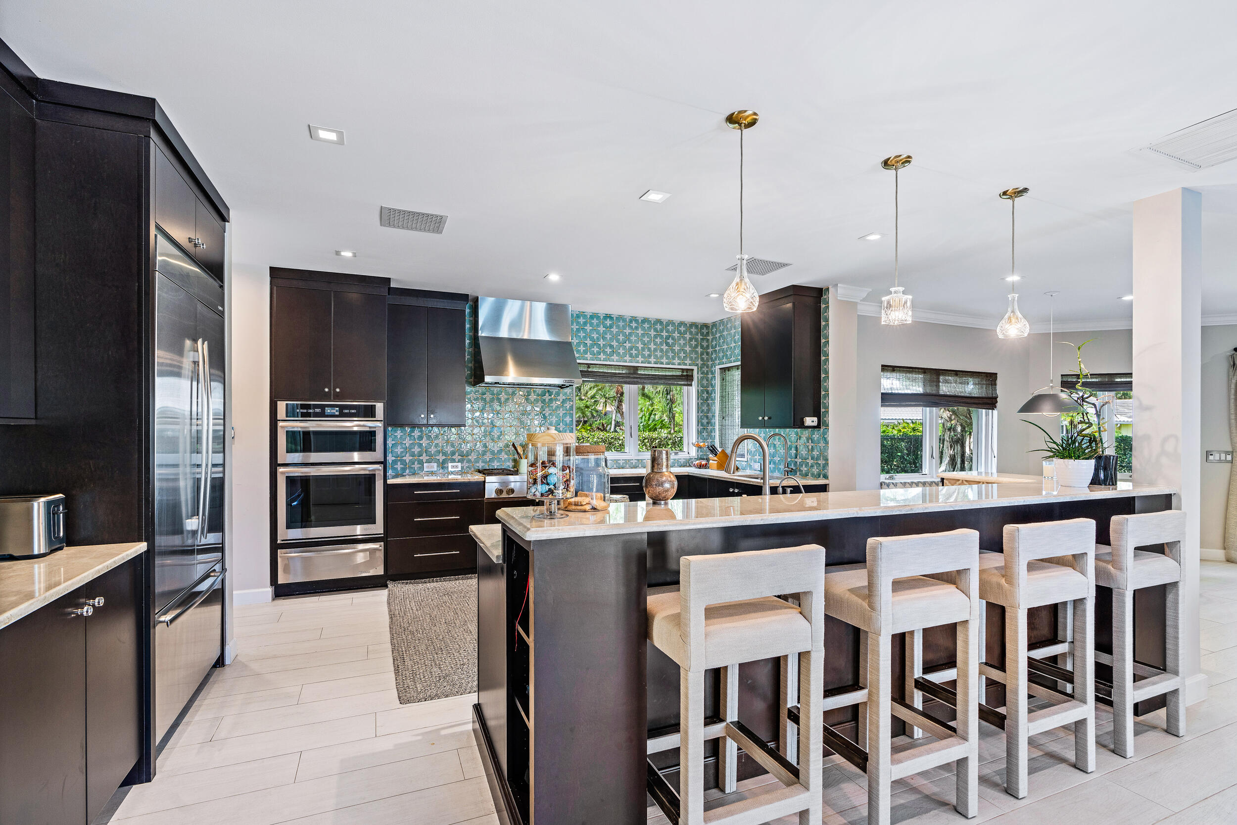 3 Sheldrake Circle Palm Beach Gardens, FL 33418 - Photo 10 of 48 a kitchen with stainless steel appliances granite countertop a stove top oven a sink dishwasher a dining table and chairs