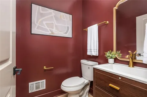 a bathroom with a granite countertop toilet sink and mirror
