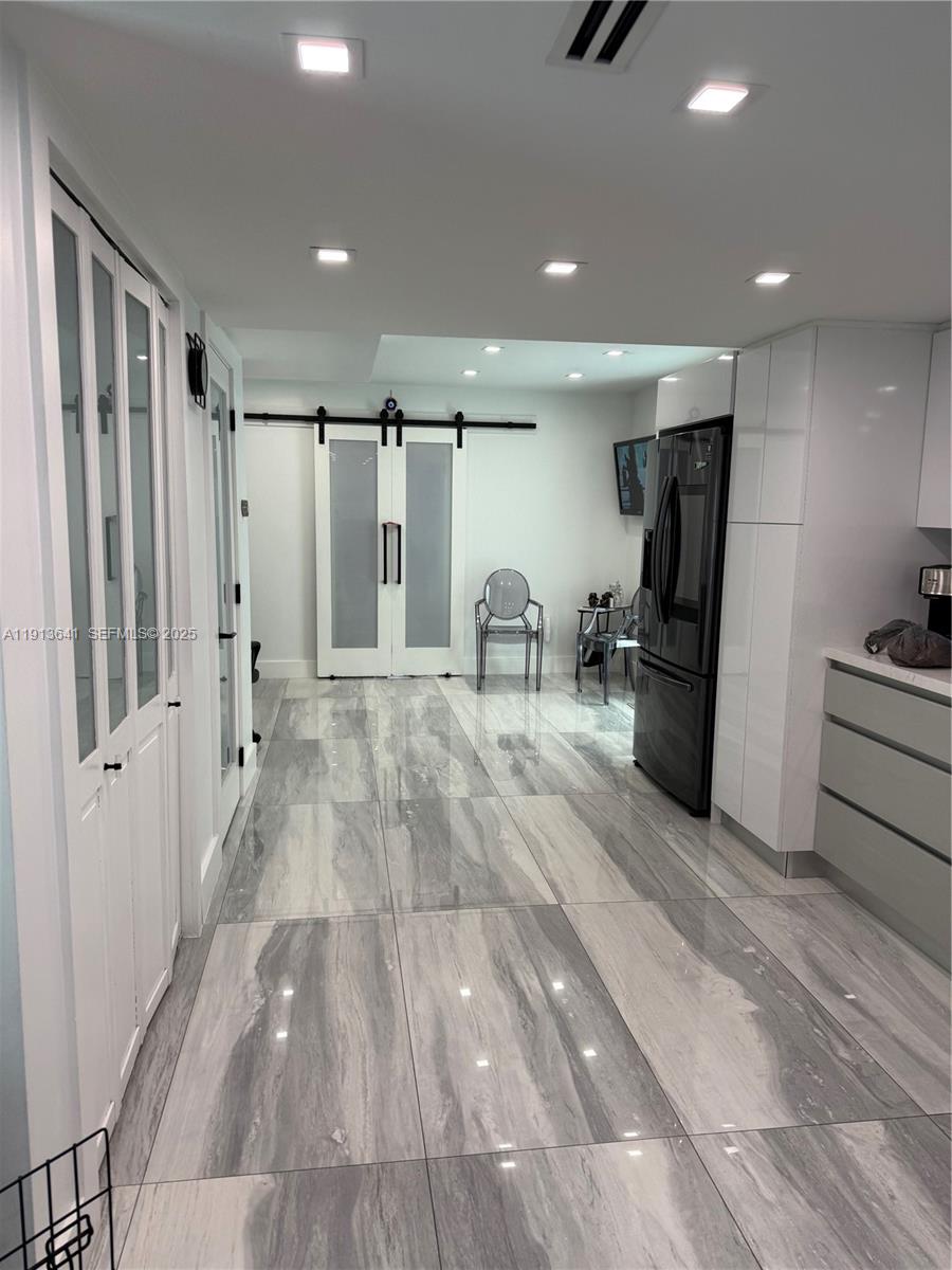 717 Tamiami Canal Road Miami, FL 33144 - Photo 11 of 15 a view of a kitchen with refrigerator and wooden floor