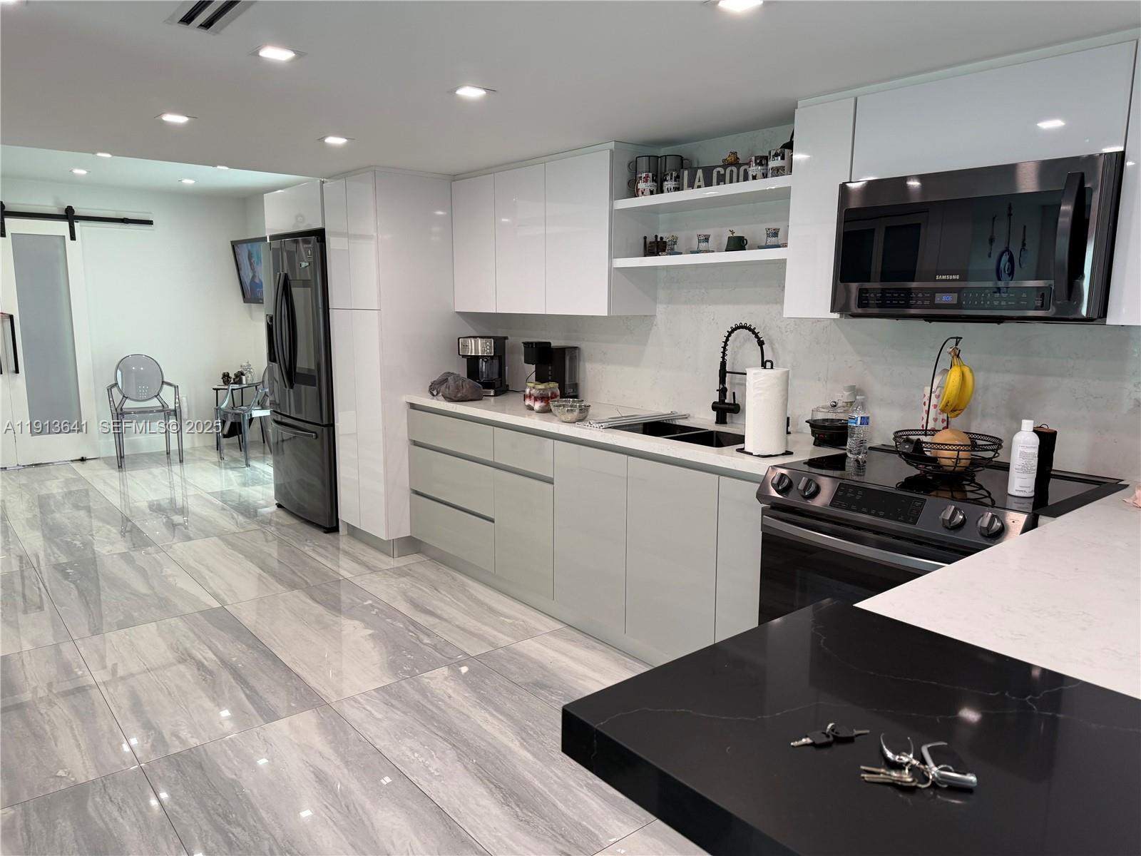 717 Tamiami Canal Road Miami, FL 33144 - Photo 10 of 15 a kitchen with a sink a stove and refrigerator