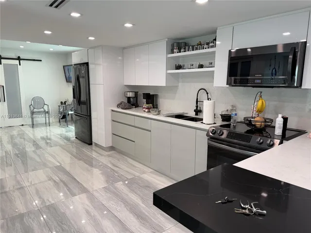 a view of a kitchen with refrigerator and wooden floor